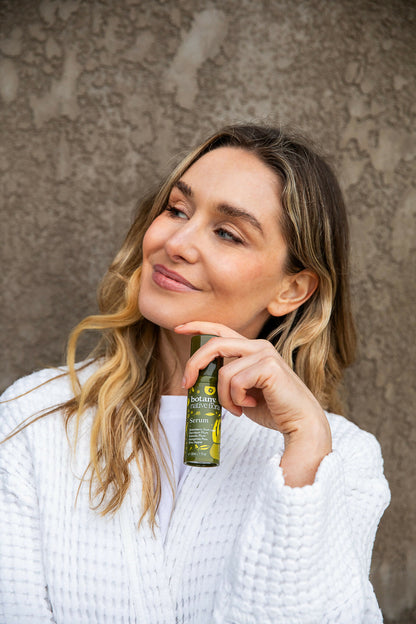 Woman holding Australian Native Flora vitamin C serum for glowing healthy skin