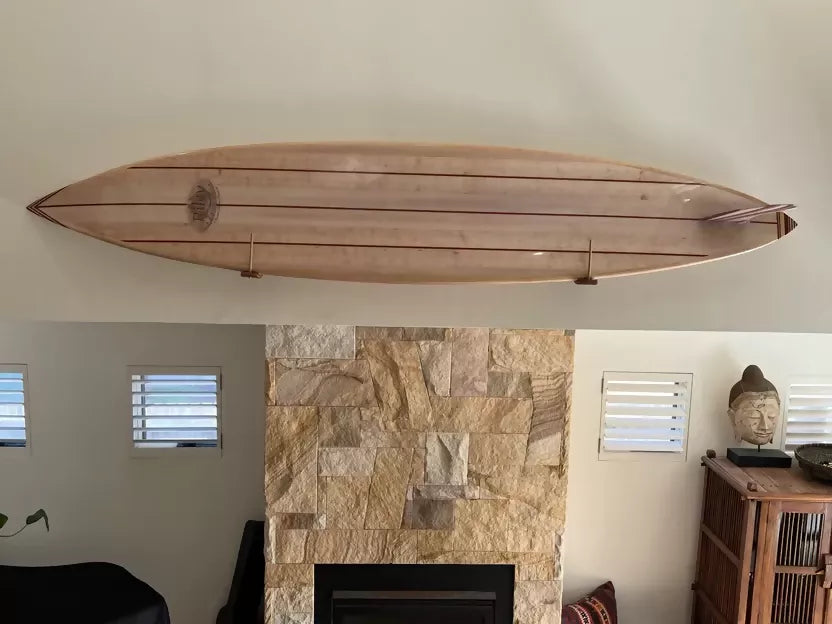 Side profile of the solid balsa Hawaiian Gun surfboard displayed indoors