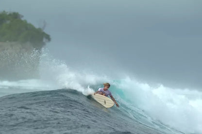 Surfer riding a wave on a Riley foam core balsa Fish surfboard
