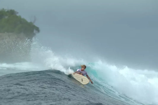Surfer riding a wave on a Riley foam core balsa Fish surfboard
