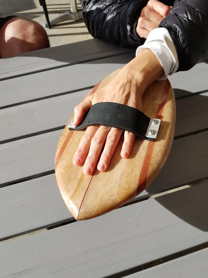 Riley solid balsa bodysurfing handboard fitted to a hand with rubber strap