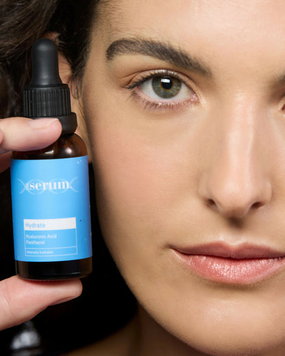 Woman holding Australian hydrating face serum with hyaluronic acid for glowing healthy skin