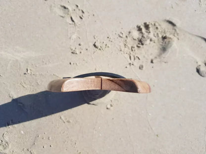 Low side view of a Riley solid balsa bodysurfing handboard on the sand