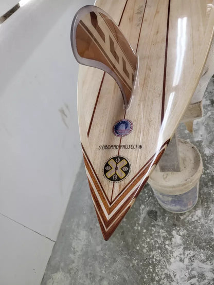 Close-up of the pointed timber tail and fin area of the Hawaiian Gun surfboard